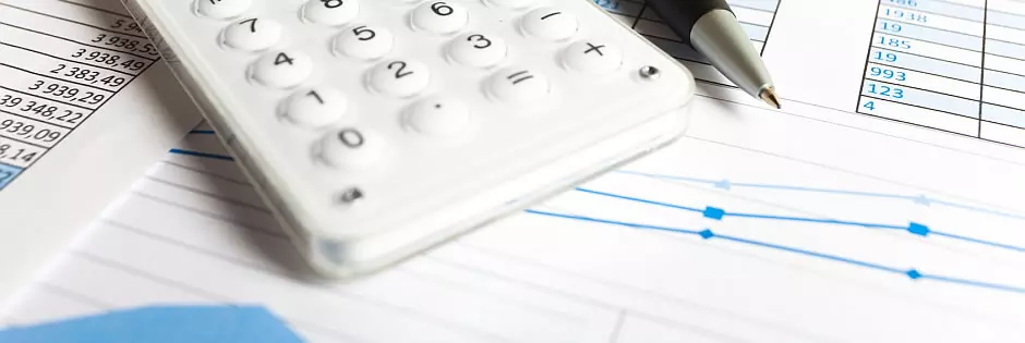 Taschenrechner, ausgedruckte Tabellen und ein Kugelschreiber zur manuellen Berechnung